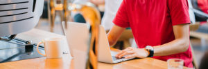 Mann sitzt an der Theke mit Laptop